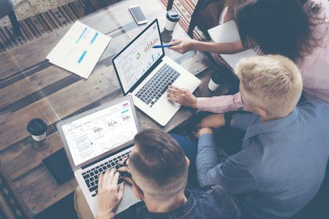 Three people accessing the Meltwater platform via laptops, for a blog about trend forecasting.