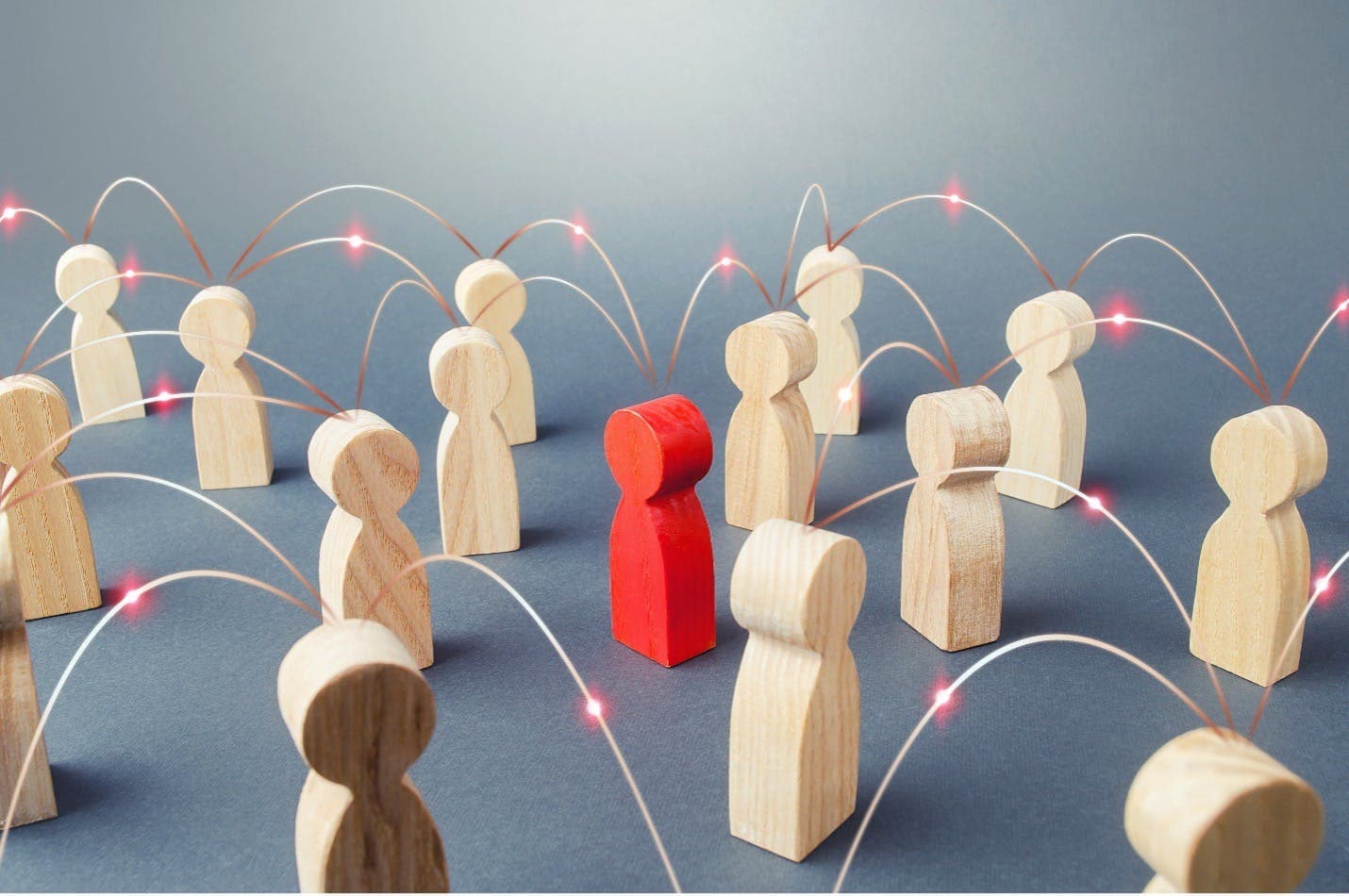 A red wooden figure connects with plain wooden figures in this image for a blog about user-generated content.