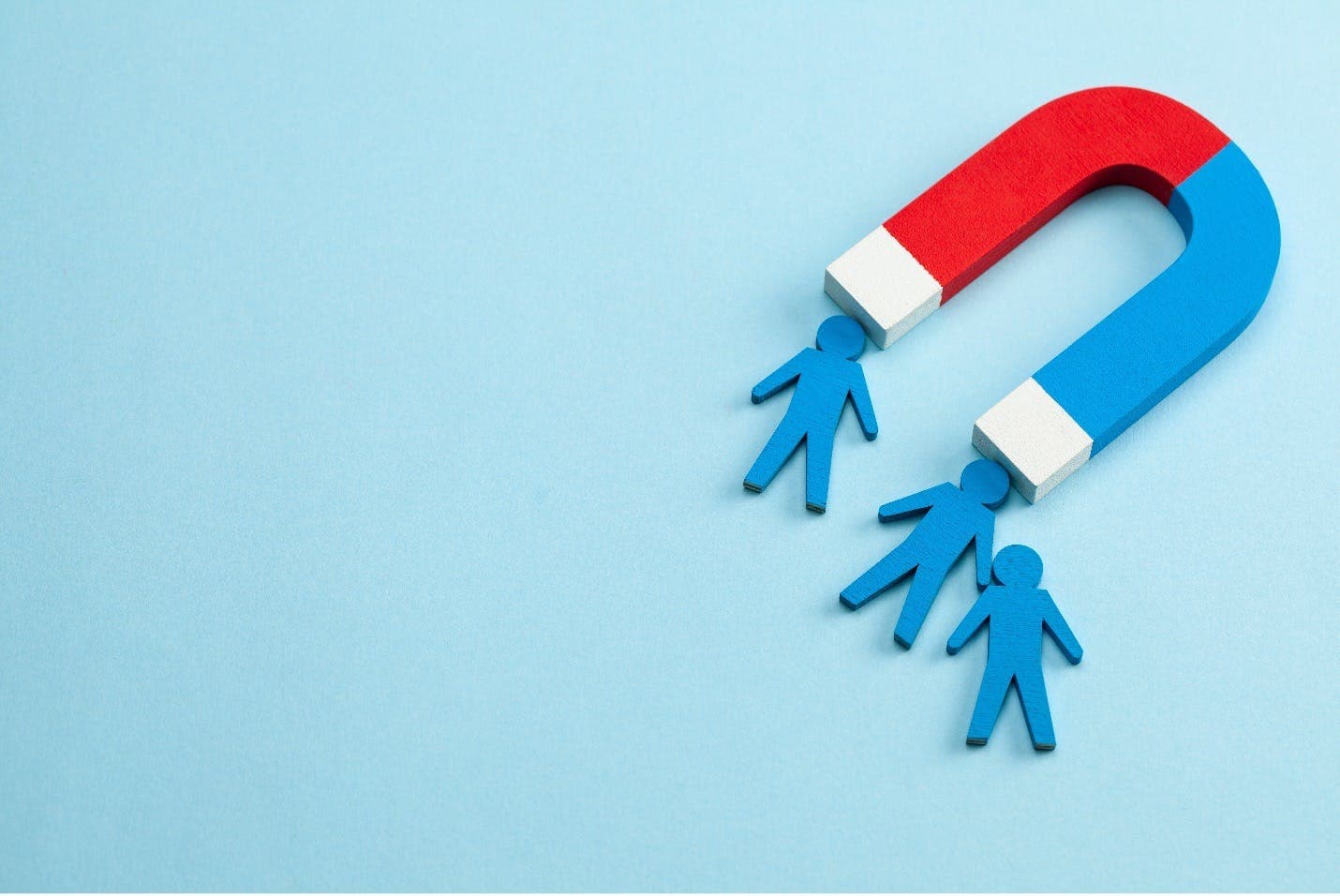 Human figures stick to a magnet in this image for a blog about user-generated content.