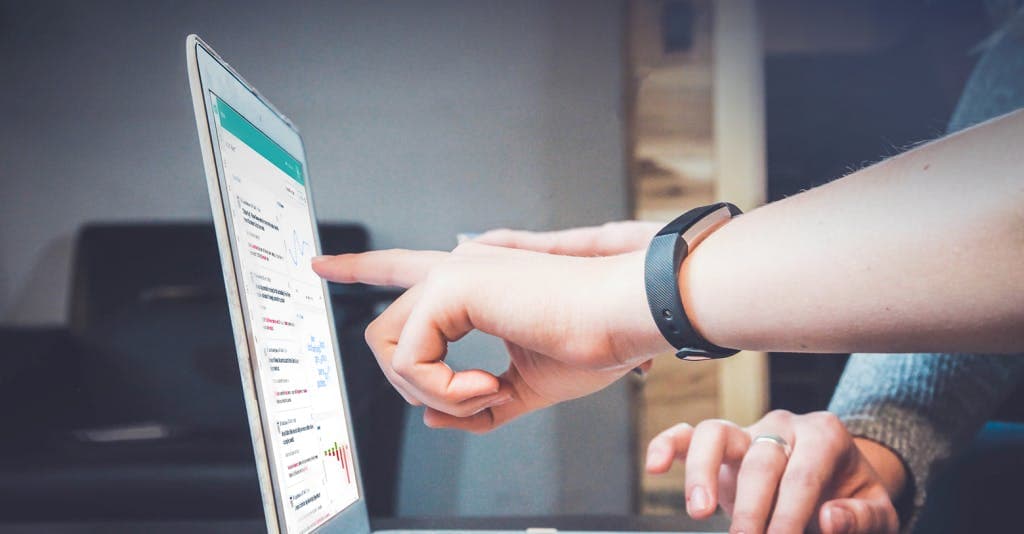 fingers pointing at a computer screen