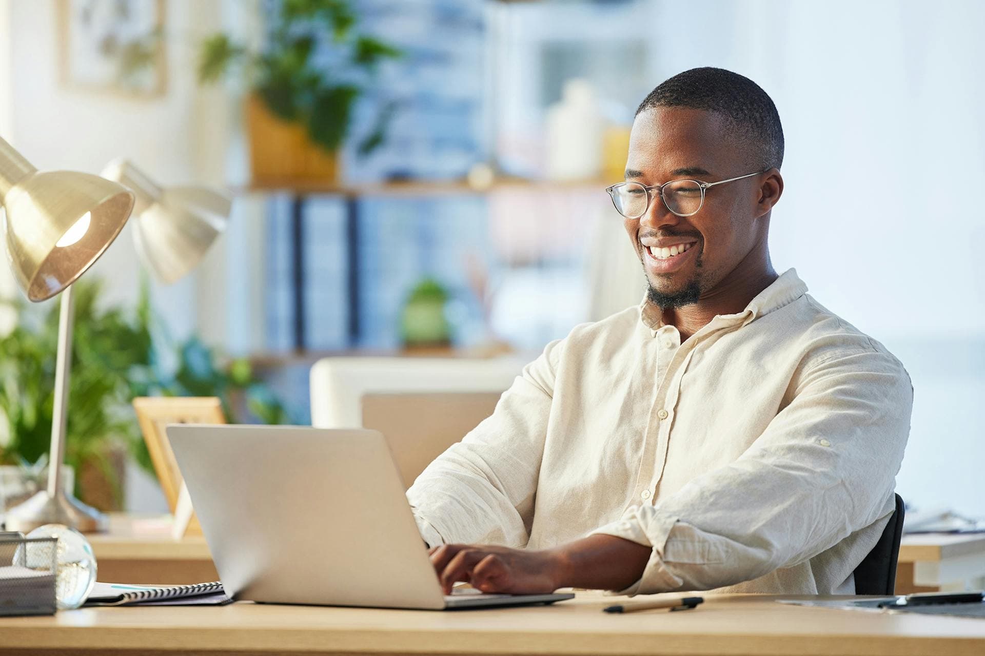 A smiling business man working on a laptop.