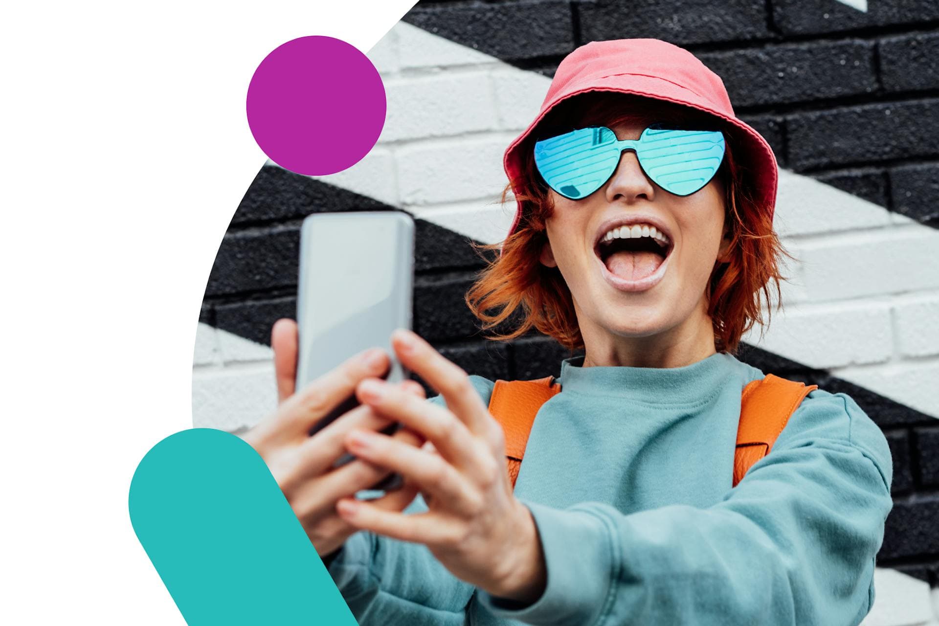 Das Bild zeigt einen jungen Influencer vor einer schwarz-weißen Backsteinmauer, der ein Telefon hält. Ultimativer Leitfaden für Influencer Marketing